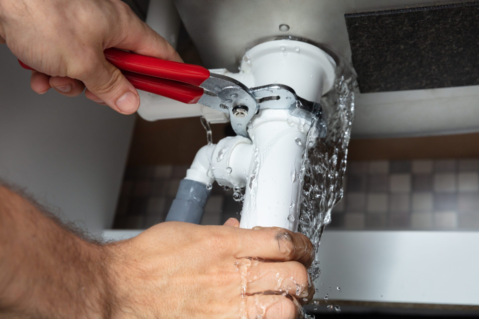 Plumber Fixing Sink Pipe With Adjustable Wrench Plumber Fixing Sink Pipe With Adjustable Wrench