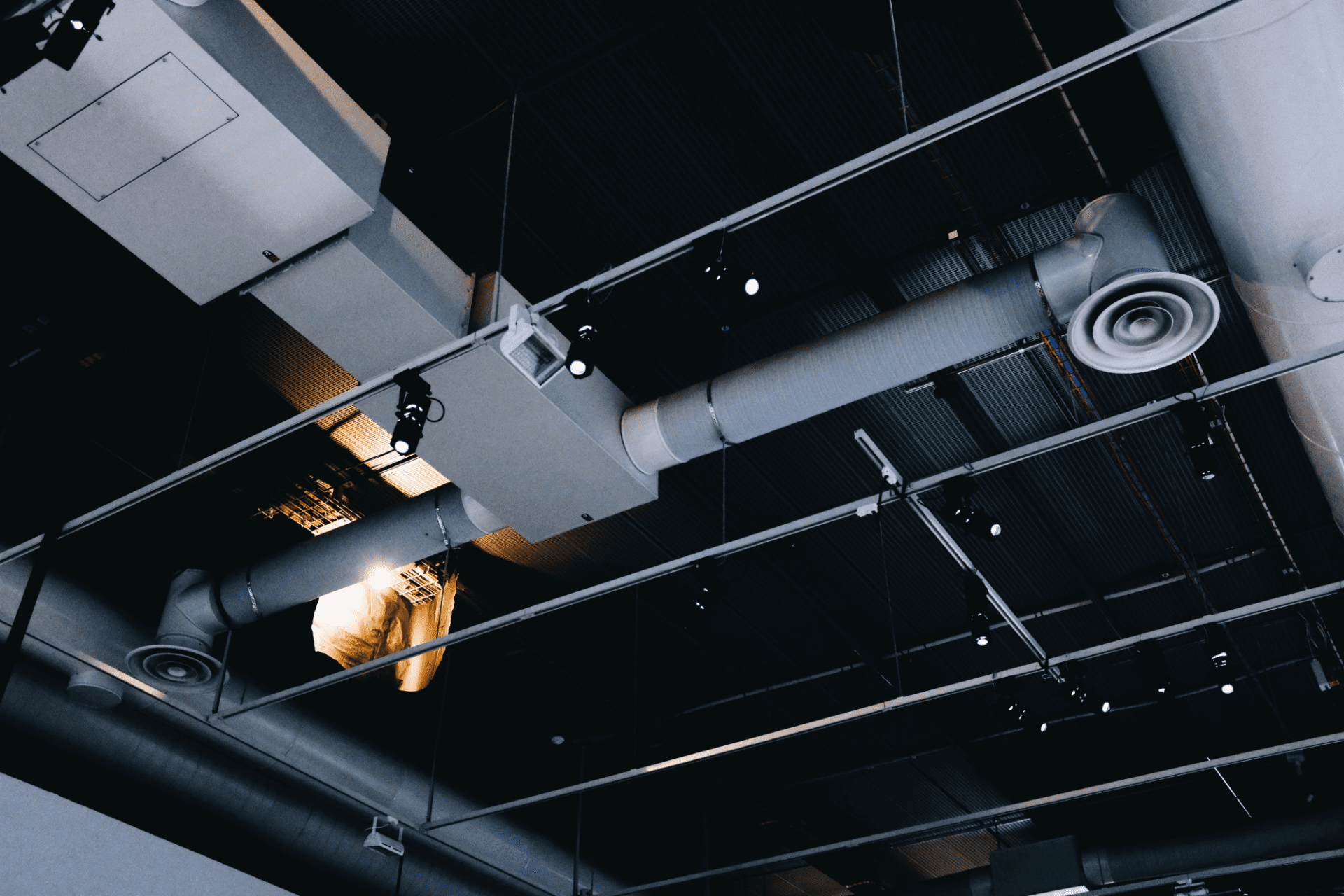 low angle shot of a metal black ceiling with white ventilation pipes low angle shot of a metal black ceiling with white ventilation pipes